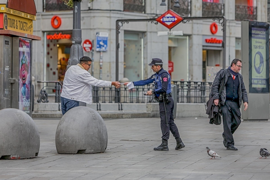 Un policía municipal de Madrid pone una multa a un viandante por no respetar la cuarentena en Madrid. Foto: EP