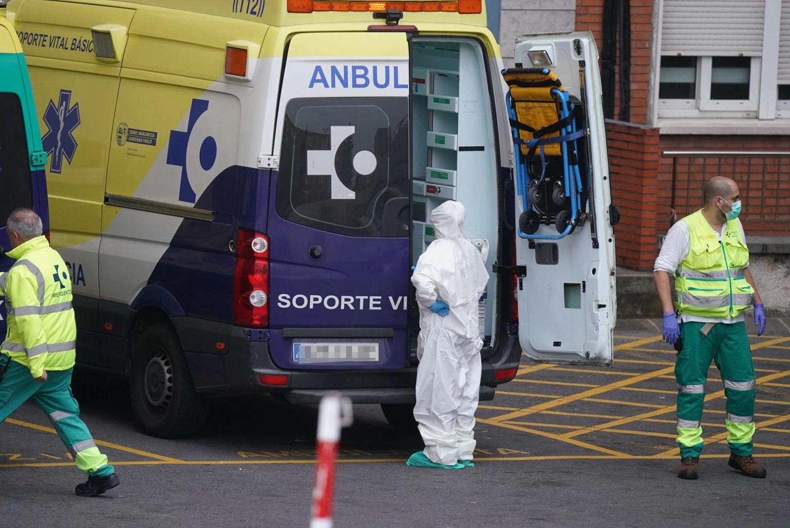 Varios sanitarios protegidos, uno con un traje y otro con mascarilla y guantes de látex, junto a una ambulancia en el Hospital Universitario Cruces, uno de los hospitales públicos vascos de referencia para infectados por coronavirus / Europa Press