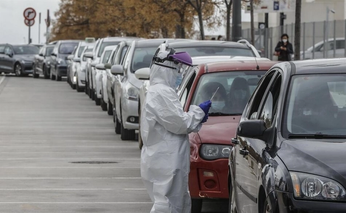 Un sanitario realiza una prueba PCR a una persona desde su vehículo. Foto: EP