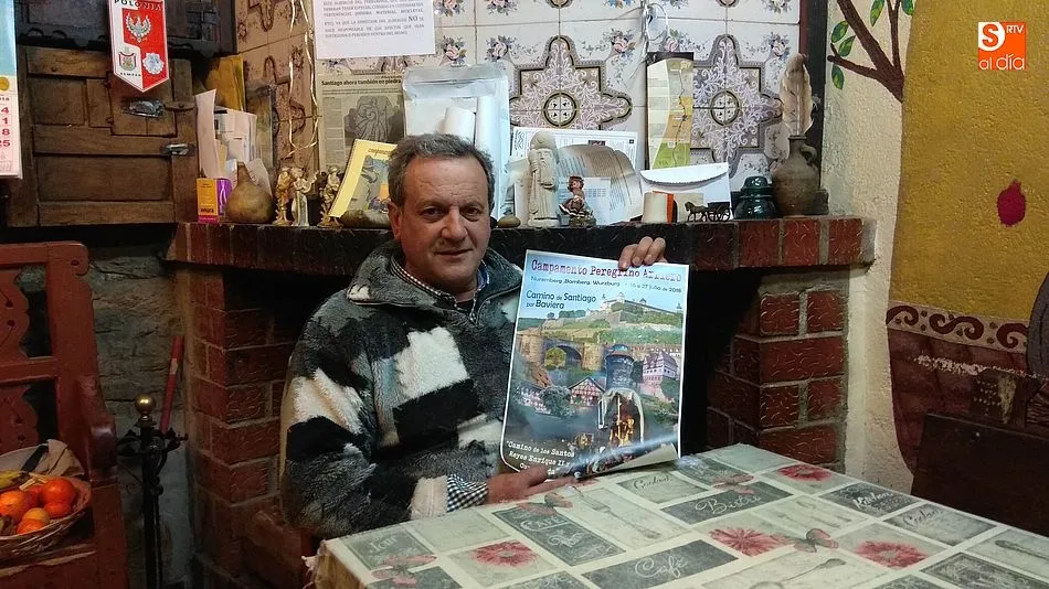 Blas Rodríguez en el albergue del peregrino de Fuenterroble con el cartel del viaje a Baviera