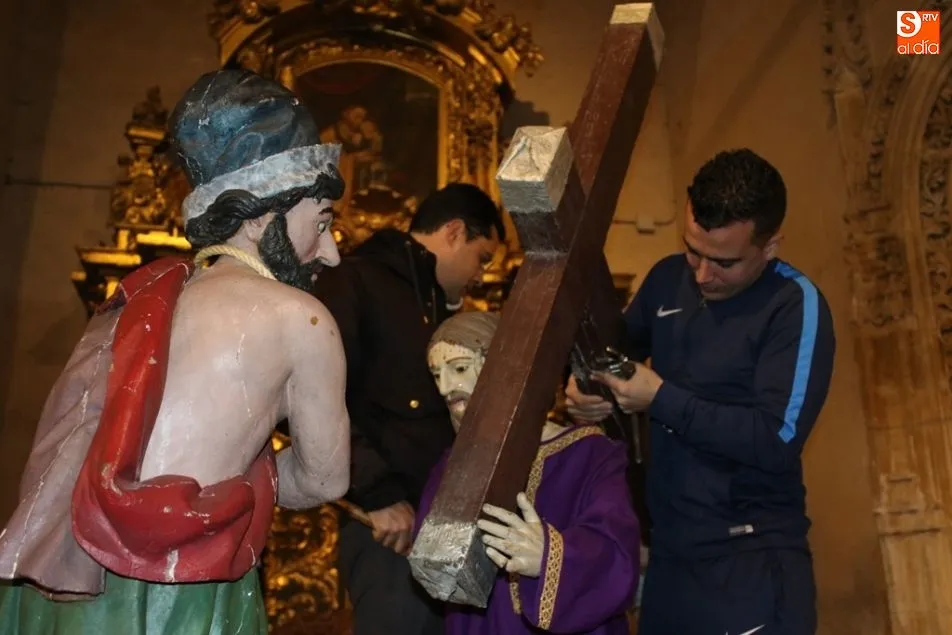 Dos cofrades durante el montaje del paso del Cirineo