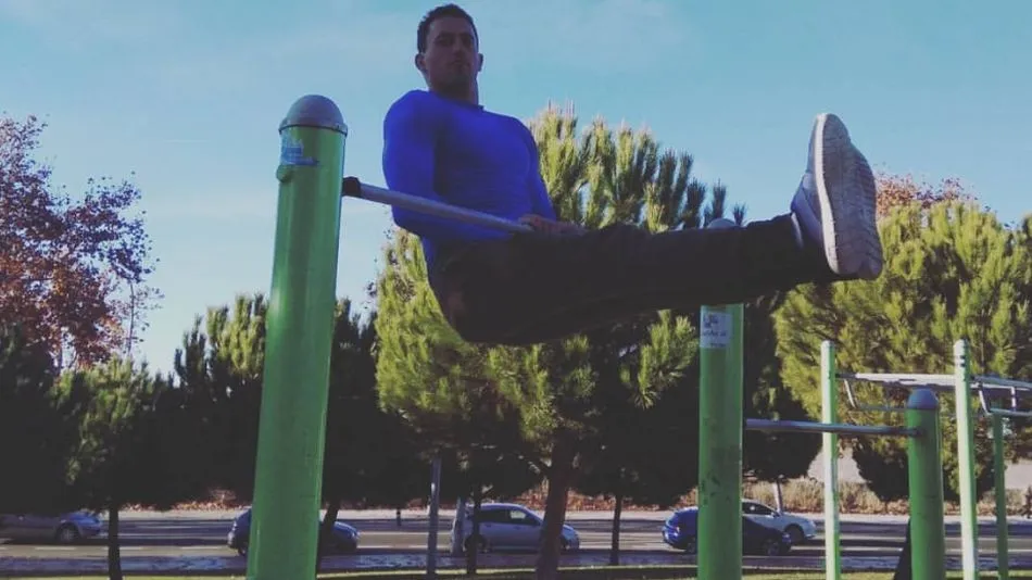 Un joven realiza un ejercicio en un gimnasio al aire libre.