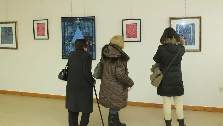 Varios visitantes observan algunas de las obras expuestas.