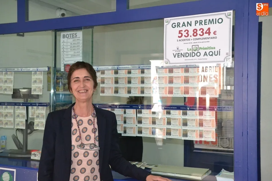 La responsable de la Administración, Marisa, con el cartel anunciador del premio