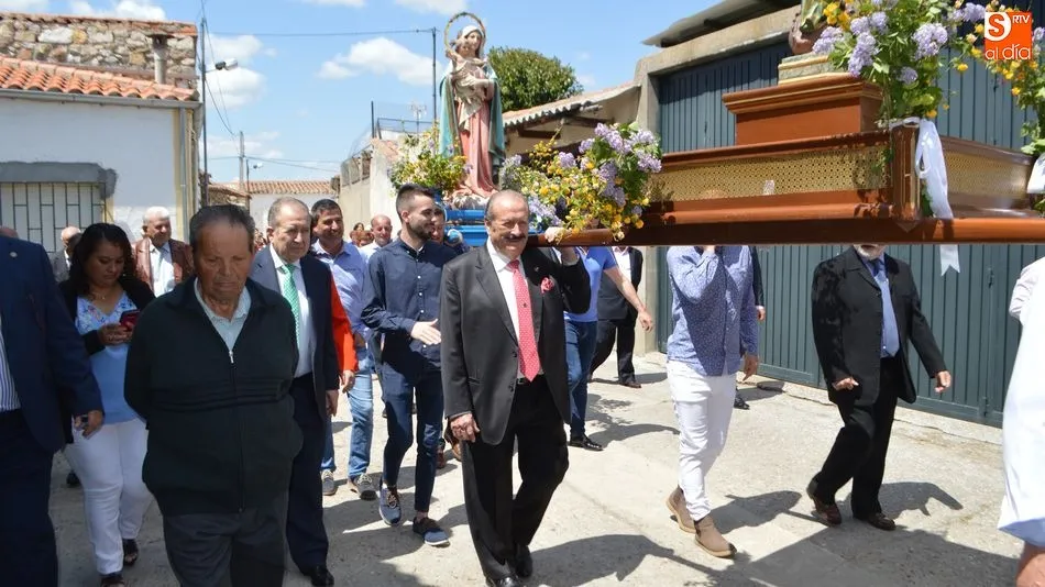 Un instante de la procesión con los vecinos, entre ellos el empresario Silvestre Sánchez, cargando con los pasos. Fotos: Ángel Merino