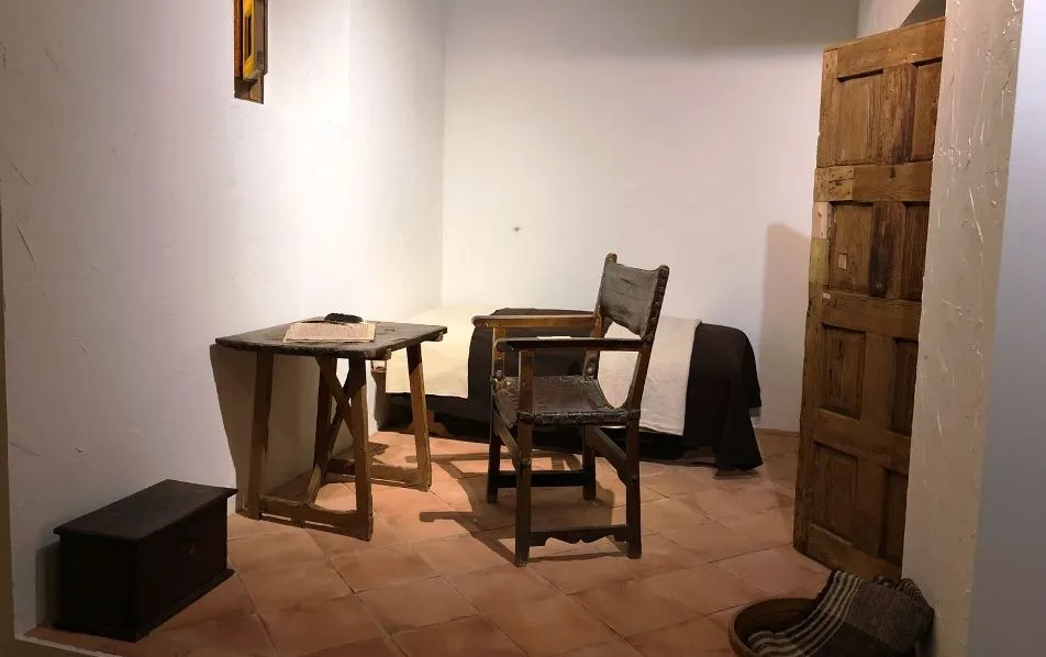 Reproducción de la celda de San Juan de la Cruz junto al códice de sus obras