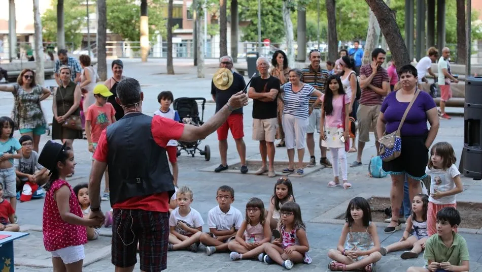 El mago Oski realiza un truco con una niña ante la atenta mirada del público. Fotos: Alberto Martín