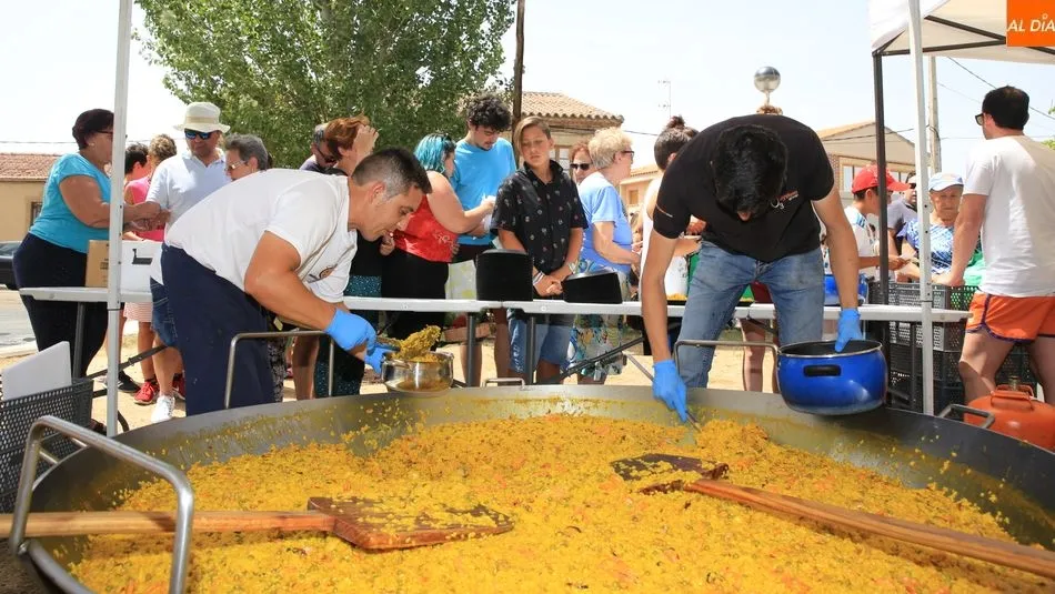 Los vecinos esperan expecantes a recoger su ración de la exquisita paella. Fotos: Alberto Martín