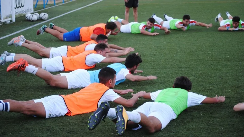 Los futbolistas realizan ejercicios durante el primer entrenamiento.