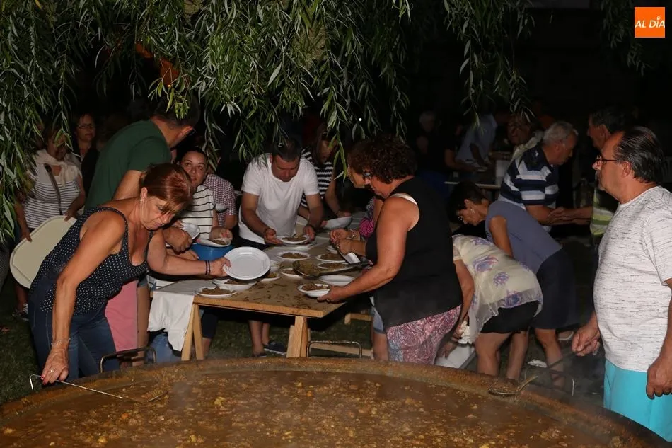 Varios vecinos reparten la carne con patatas