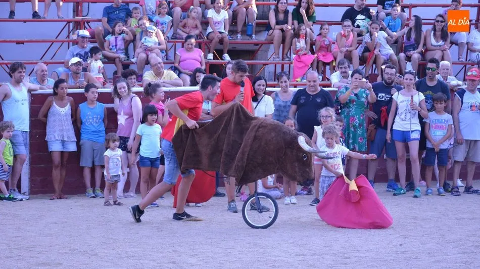 Un niño se luce con el capote ante un carretón en el encierro infantil / E. Corredera