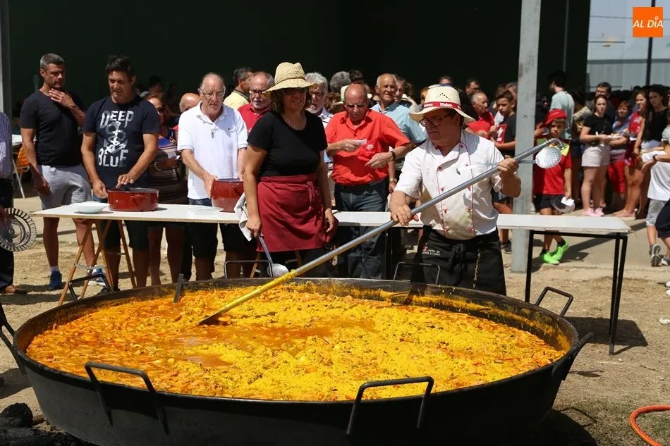 Los vecinos esperan a que empiece el reparto de la paella