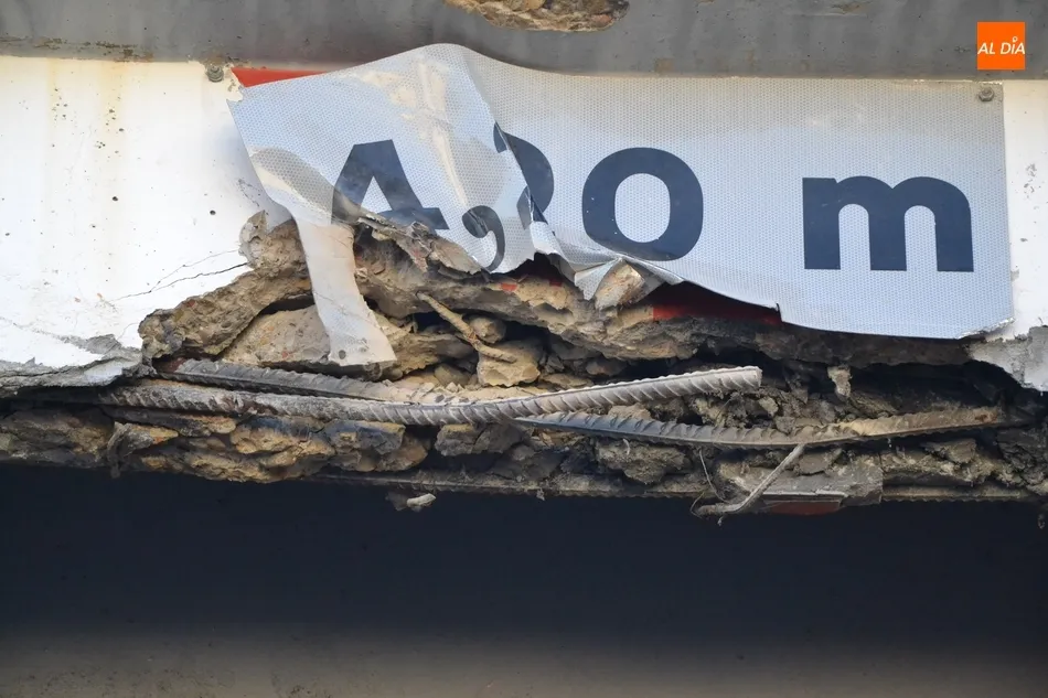 Un camión cargado con una excavadora impacta contra la parte superior del paso de la vía del tren ...