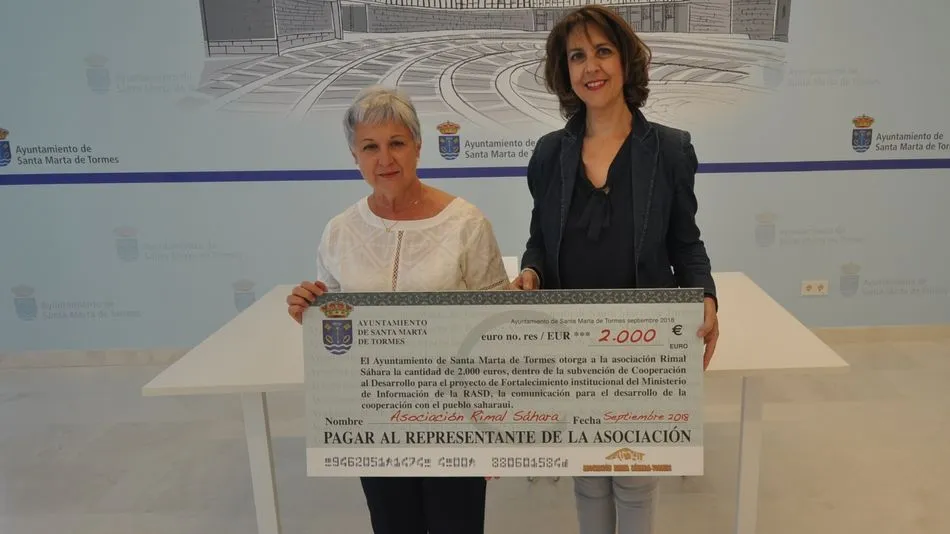 La presidenta de Rimal Sáhara, Rosa Alonso, recibe el cheque de manos de la concejala Andrea García