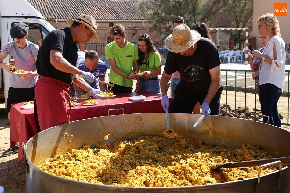 Varios vecinos recogen sus platos de paella