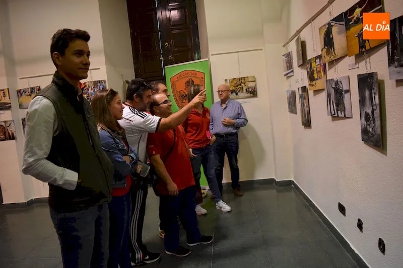 Asistentes a la exposición observan las imágenes