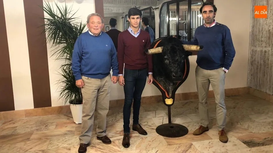 El presidente de la peña junto al taxidermista y Manuel Diosleguarde con la cabeza del novillo