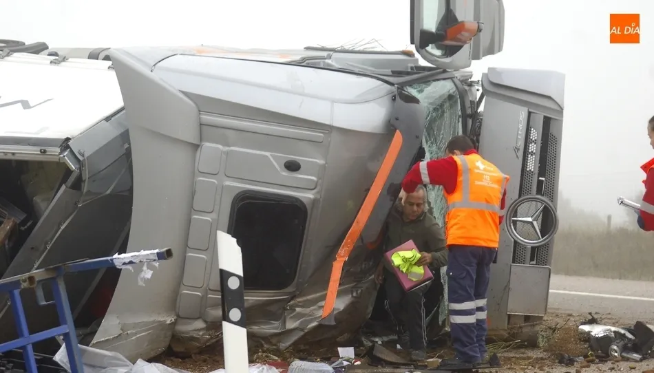 El camionero saliendo de la cabina, junto a un profesional del Servicio de Emergencias. Fotos de Adrián Martín