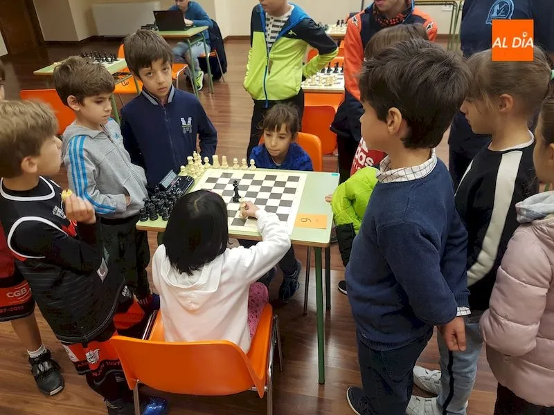 Los niños permanecen atentos a una partida de ajedrez
