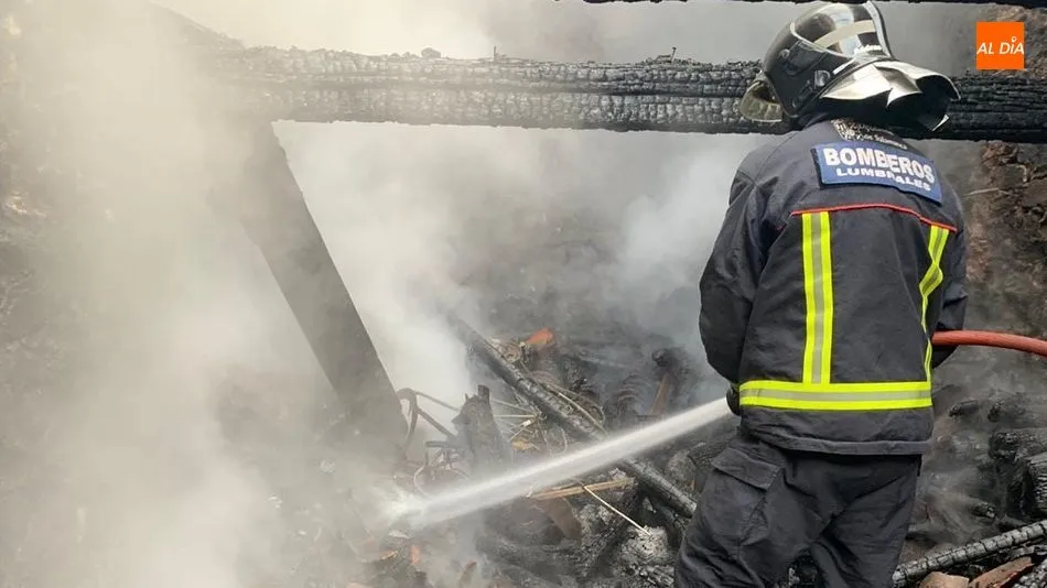 Un bombero apagando las llamas en el interior de la vivienda de Hinojosa