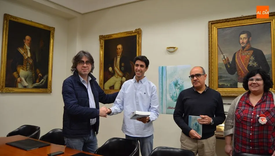 Presentación del libro ante los retratos de militar Pardiñas y los ministros Reinoso y Sánchez Ocaña, que dan nombre a la Calle Mayor