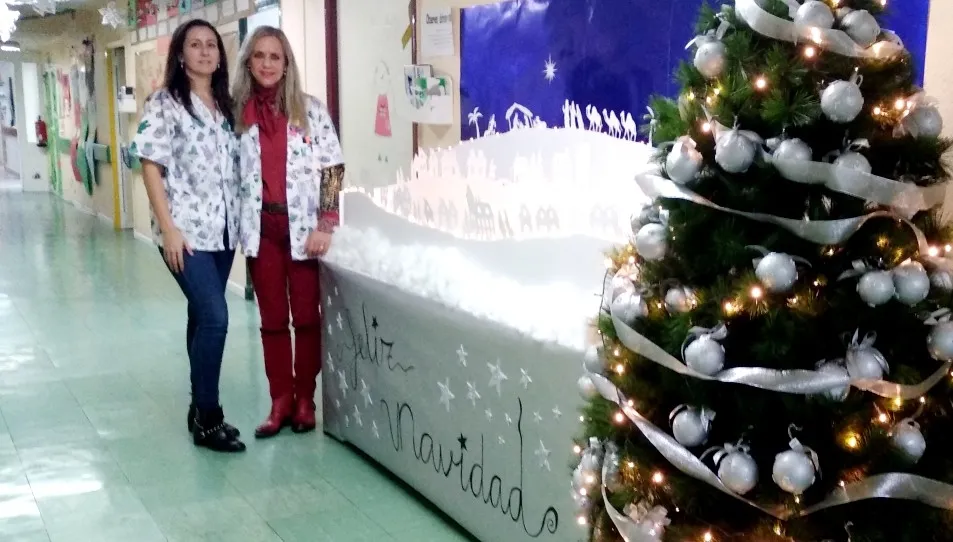 Raquel y Rosa, responsables del colegio del Hospital Clínico, junto al Belén en la planta de pediatría