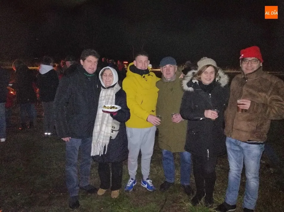 Vecinos y amigos del Arrabal de San Sebastián disfrutan a cubierto del convite de la hoguera  