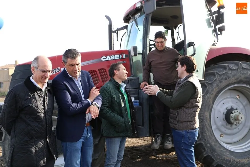 Mañueco (d) conversa con un agricultor en Villoria este jueves