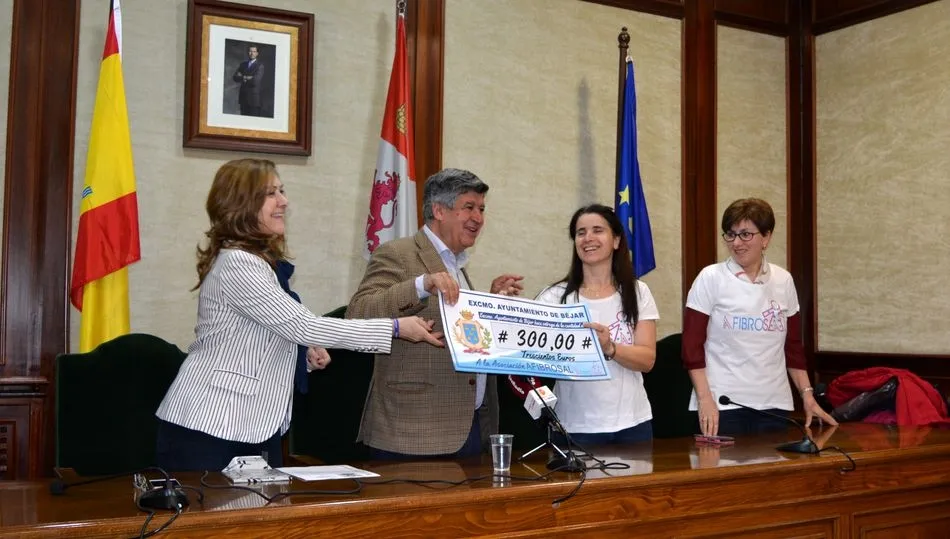 Entrega del talón con la recaudación a representantes de Afibrosal