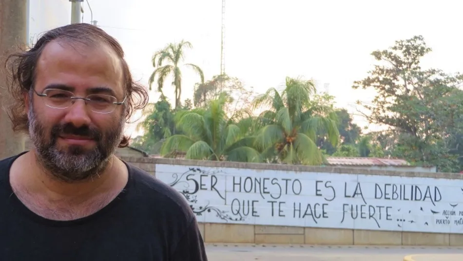 Alencart ante un mural de Acción Poética con versos suyos, en su ciudad natal