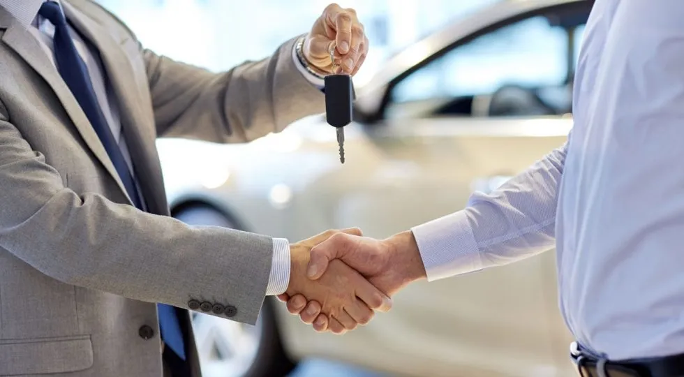 Dos personas realizan un intercambio de llaves