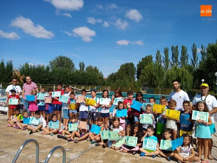 Los niños y niñas con el diploma recibido por la finalización del curso