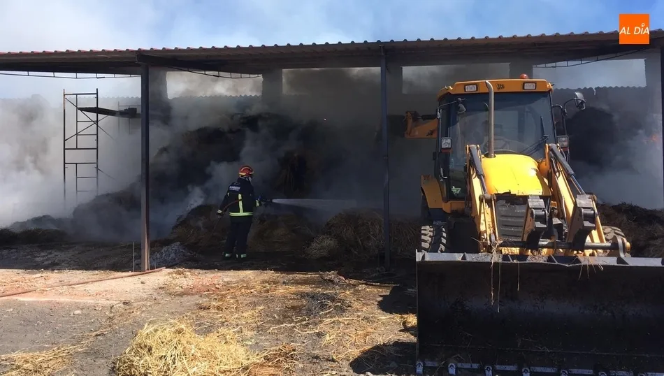 Los bomberos tratan de sofocar las llamas en la nave ganadera