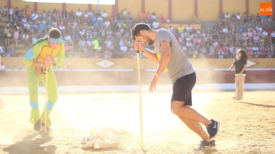 Dos jóvenes dan vueltas sobre un palo en una de las pruebas