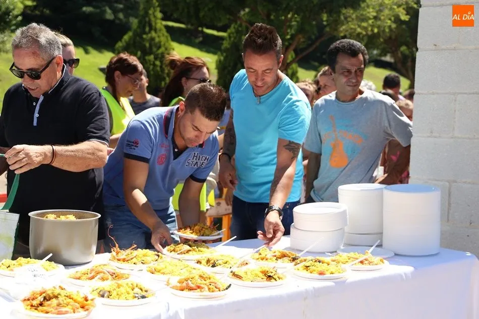 Vecinos recogen su plato de paella