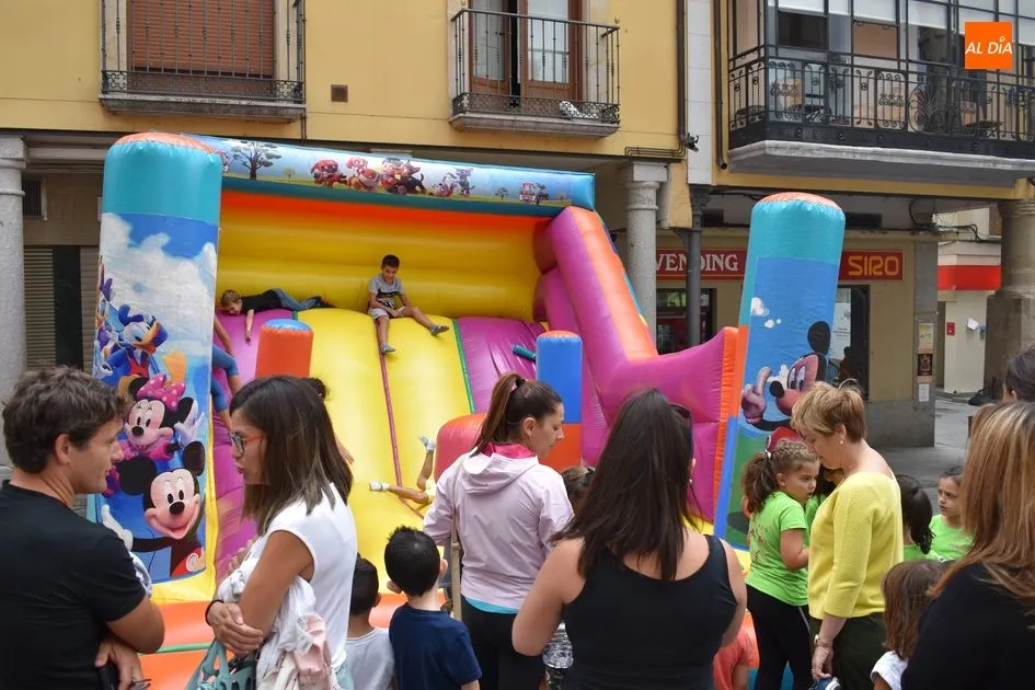 Grupo de padres ven como sus hijos montan en los hinchables