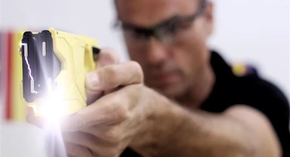 El policía instructor Miguel Berdud hace una demostración del funcionamiento de la pistola eléctrica / EP