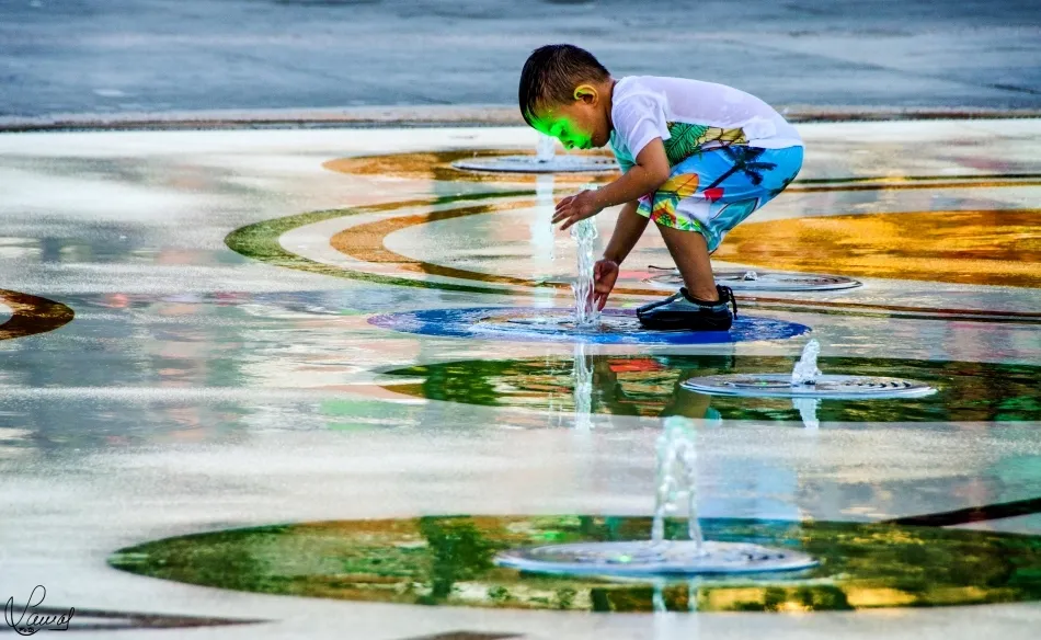 Niño jugando en una fuente del parque de Garrido
