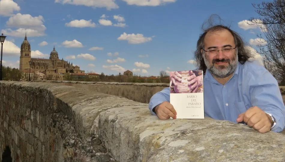 Alfredo Pérez Alencart con su libro, en el Puente Romano