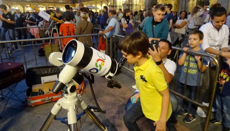 Un niño observa por un telescopio