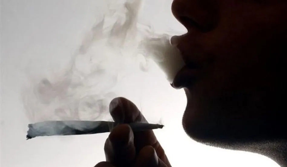 Un hombre fumando un porro de marihuana / EP