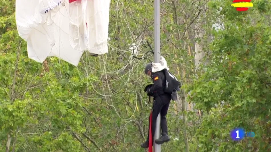 El paracaidista ha quedado colgando de la farola durante unos minutos hasta que ha sido rescatado por un VAMTAC del Ejército de Tierra, un vehículo ligero dotado con una cesta-grúa. Imagen de TVE