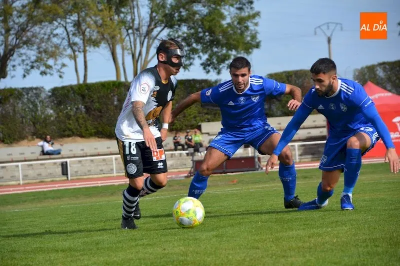 Álvaro Romero controla el balón ante la presión de dos rivales / Lydia González