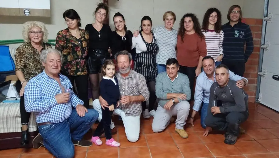 Juan en el centro agachado con su nieta Valeria y acompañado por su familia y amigos