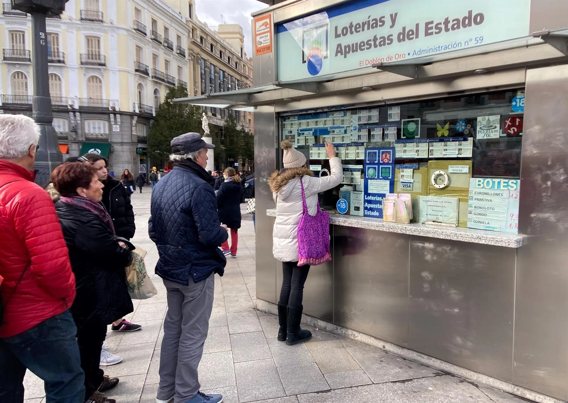 Una mujer compra un décimo de Lotería de Navidad en una Administración en la plaza de Puerta del Sol / Europa Press