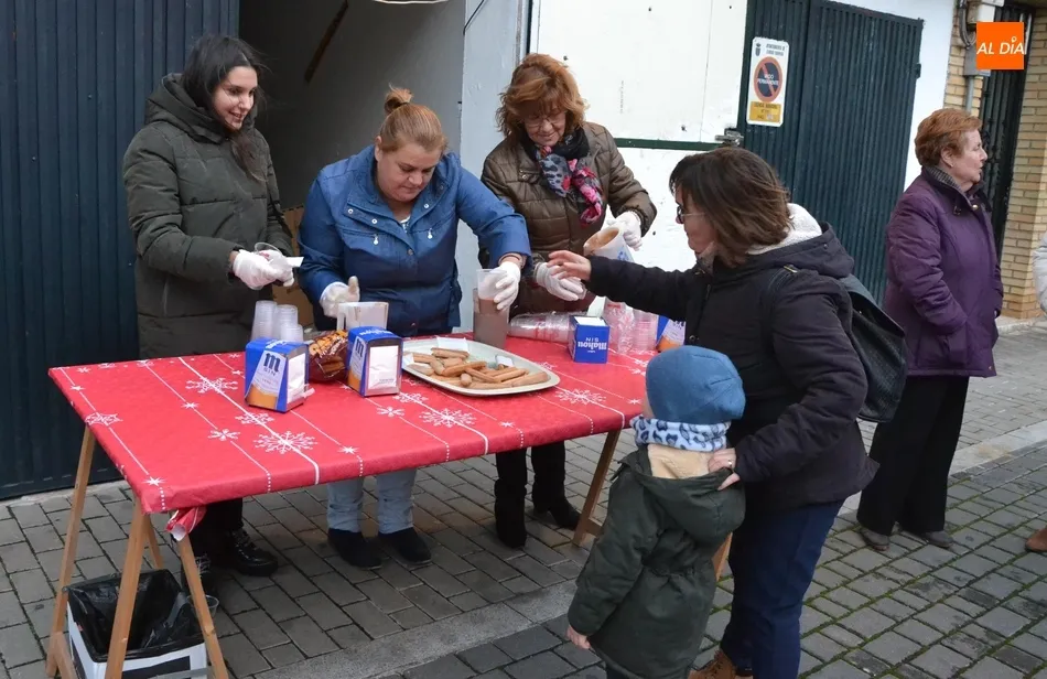 Los vecinos de la calle Valera repiten chocolatada callejera luchando contra el viento  