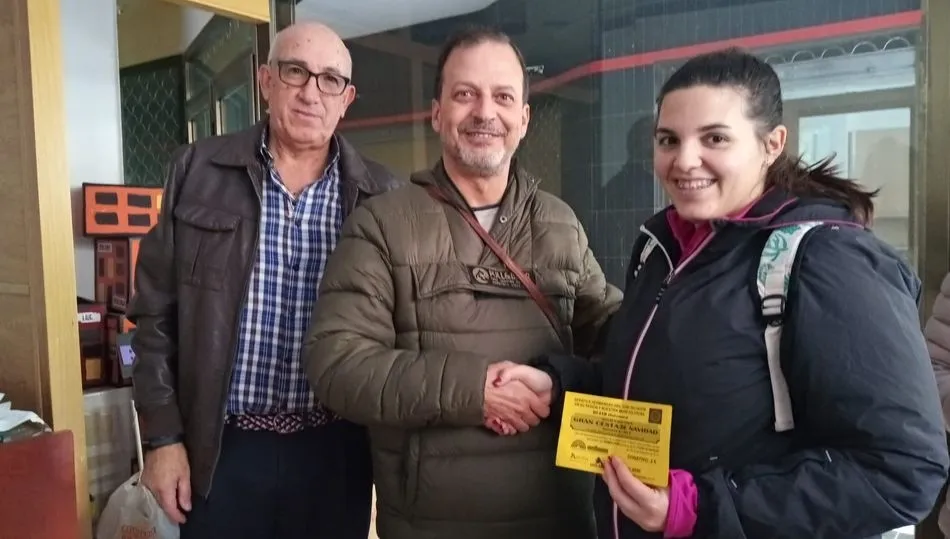 El Hermano Mayor hace entrega de la cesta de Navidad a la ganadora