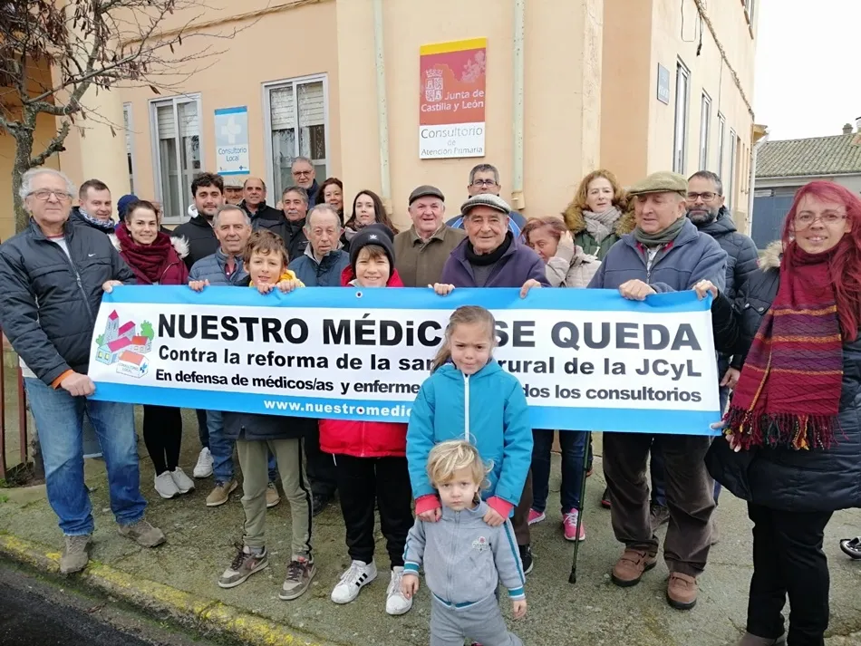 Vecinos de Huerta con la pancarta que han colocado en el balcón del ayuntamiento