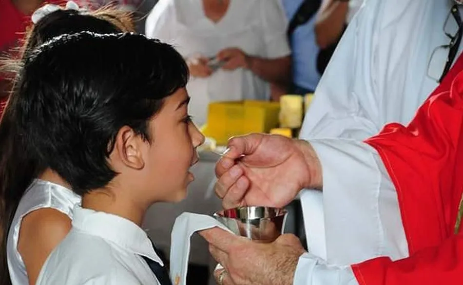 Un niño comulgando