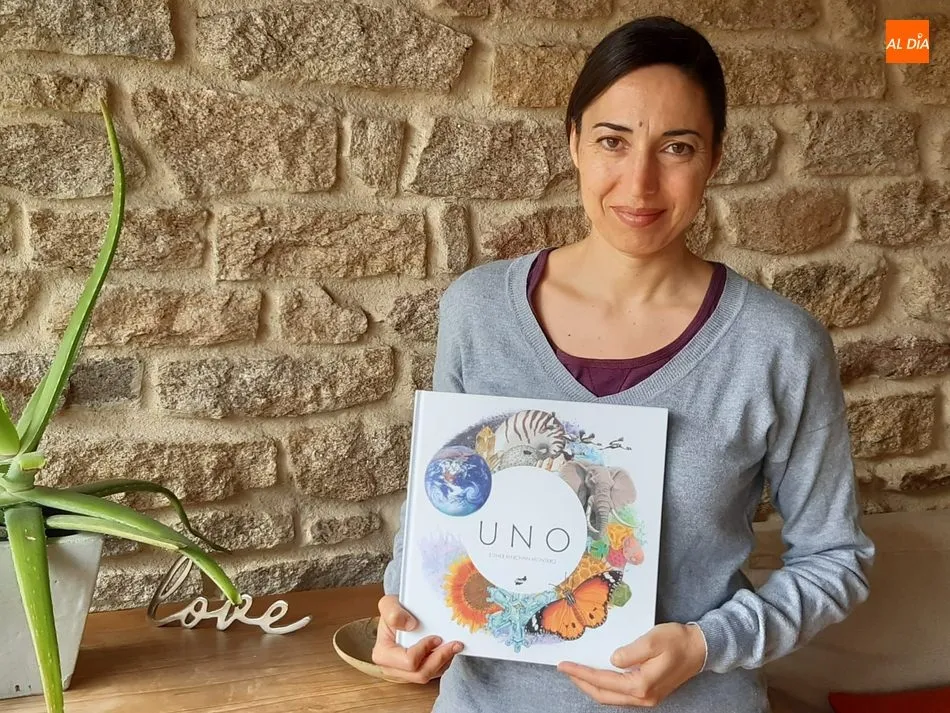 Esther Merchán Montero mostrando la portada de UNO, su primer libro de ilustraciones